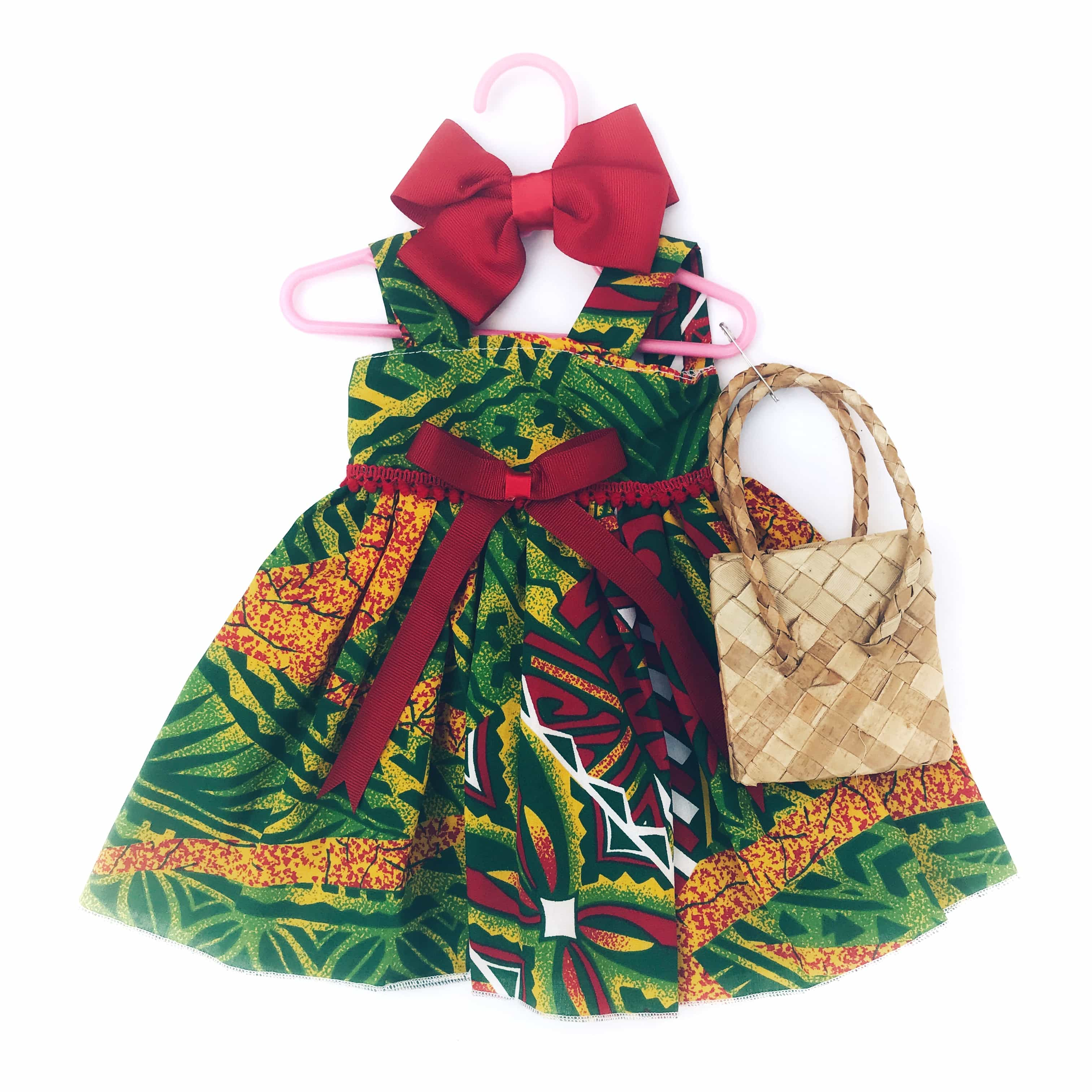 Green and red tribal print luau costume dress outfit for 18 inch American Girl Doll on a hanger with a cute woven handbag accessory