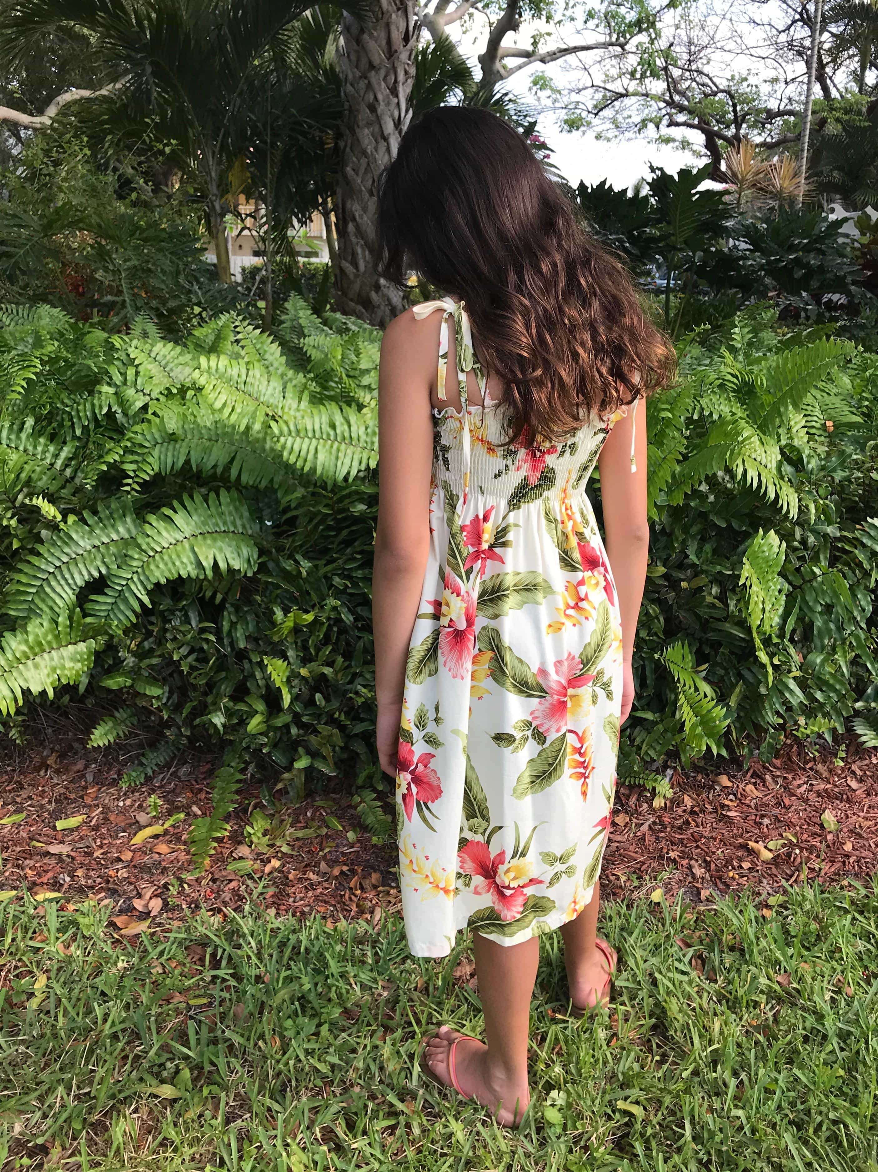 Young girl wearing a Hawaiian tie strap dress beige color with pink hibiscus flowers | Aloha Products USA