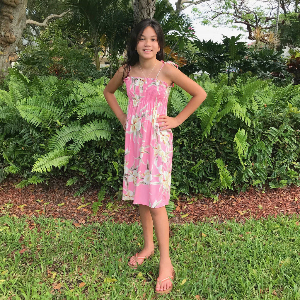 Young girl wearing a Hawaiian tie strap dress pink with white orchid flowers | Aloha Products USA
