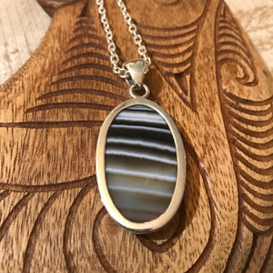 Back view of an oval shaped black sardonyx pendant necklace with stirling silver setting