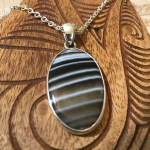 Close up view of an oval shaped black sardonyx pendant necklace with stirling silver setting | Aloha Products USA