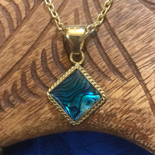 Close up view of a blue abalone shell pendant necklace square shaped with alchemia gold rope trim
