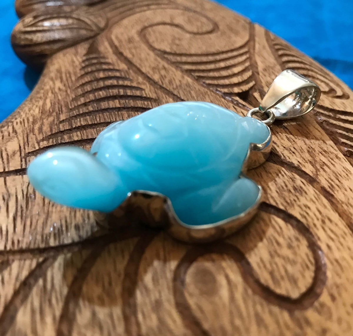 Close up view of a light blue iridescent fiber optic turtle set in stirling silver that is hand carved | Aloha Products USA