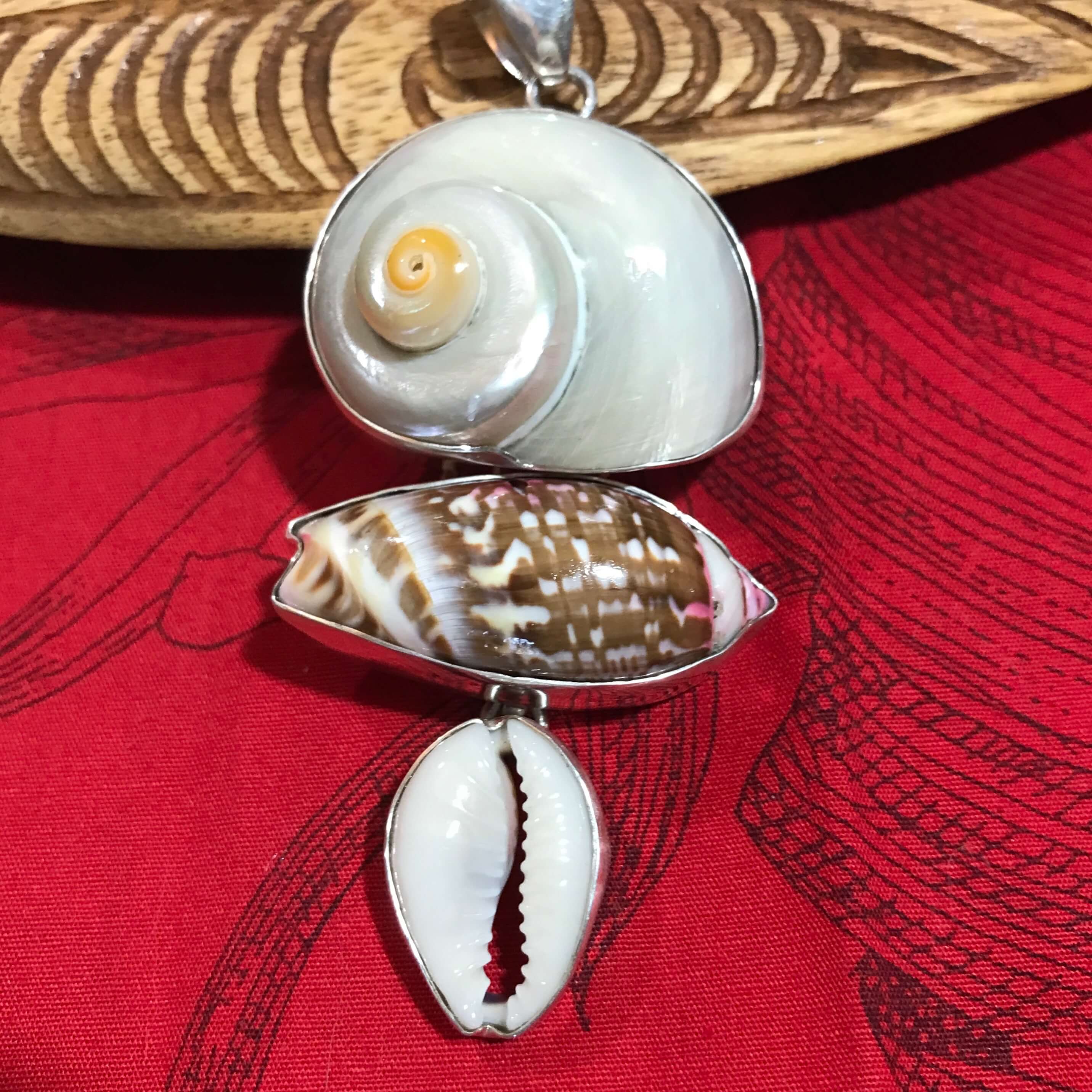 Close up view of a multi-shell pendant set in stirling silver using cinnerus, olive and cowry shells | Aloha Products USA