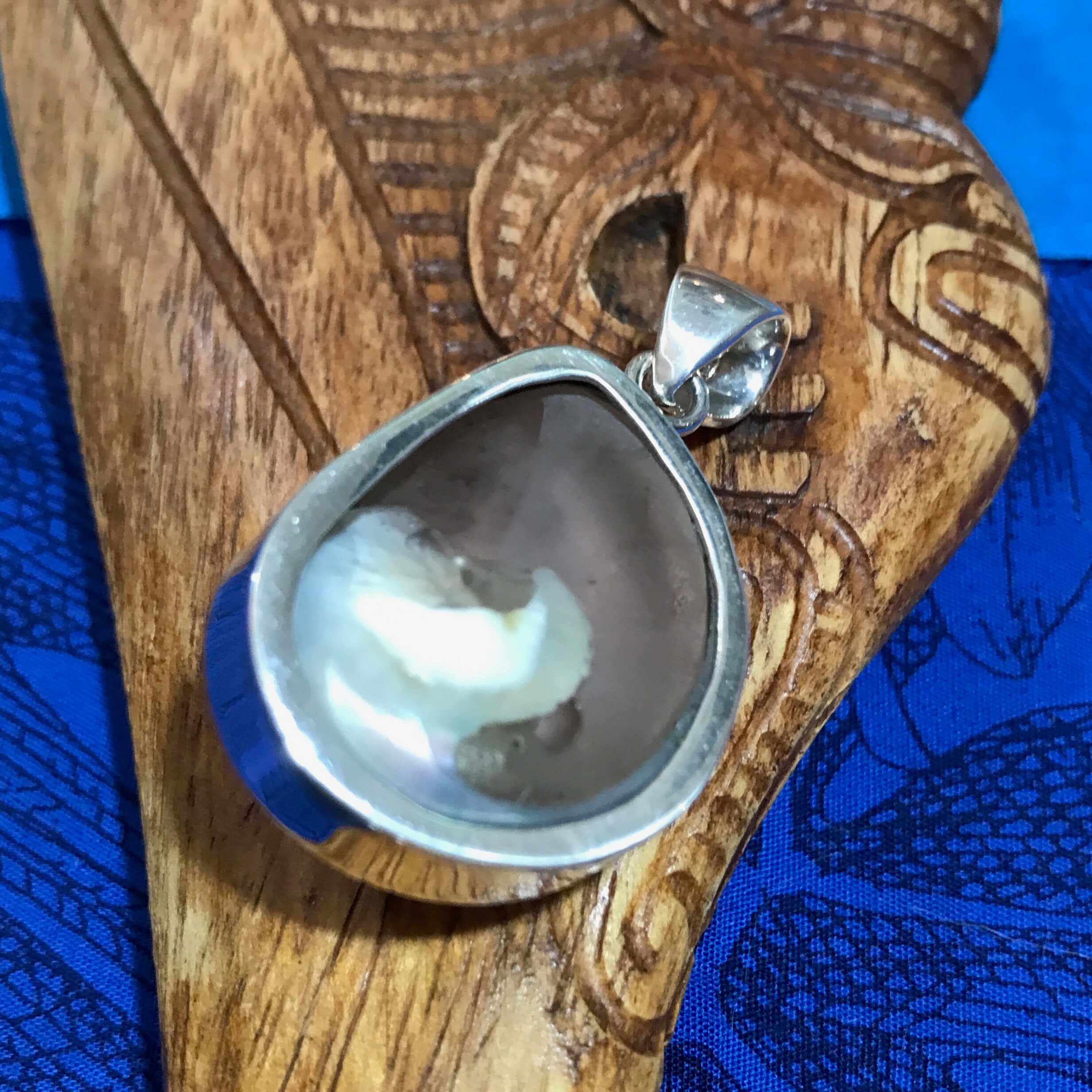 Back view of a stirling silver pendant with a cinnerus shell