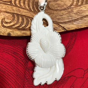 Close up view showing intricate details of a hand carved bone hibiscus flower pendant  | Aloha Products USA