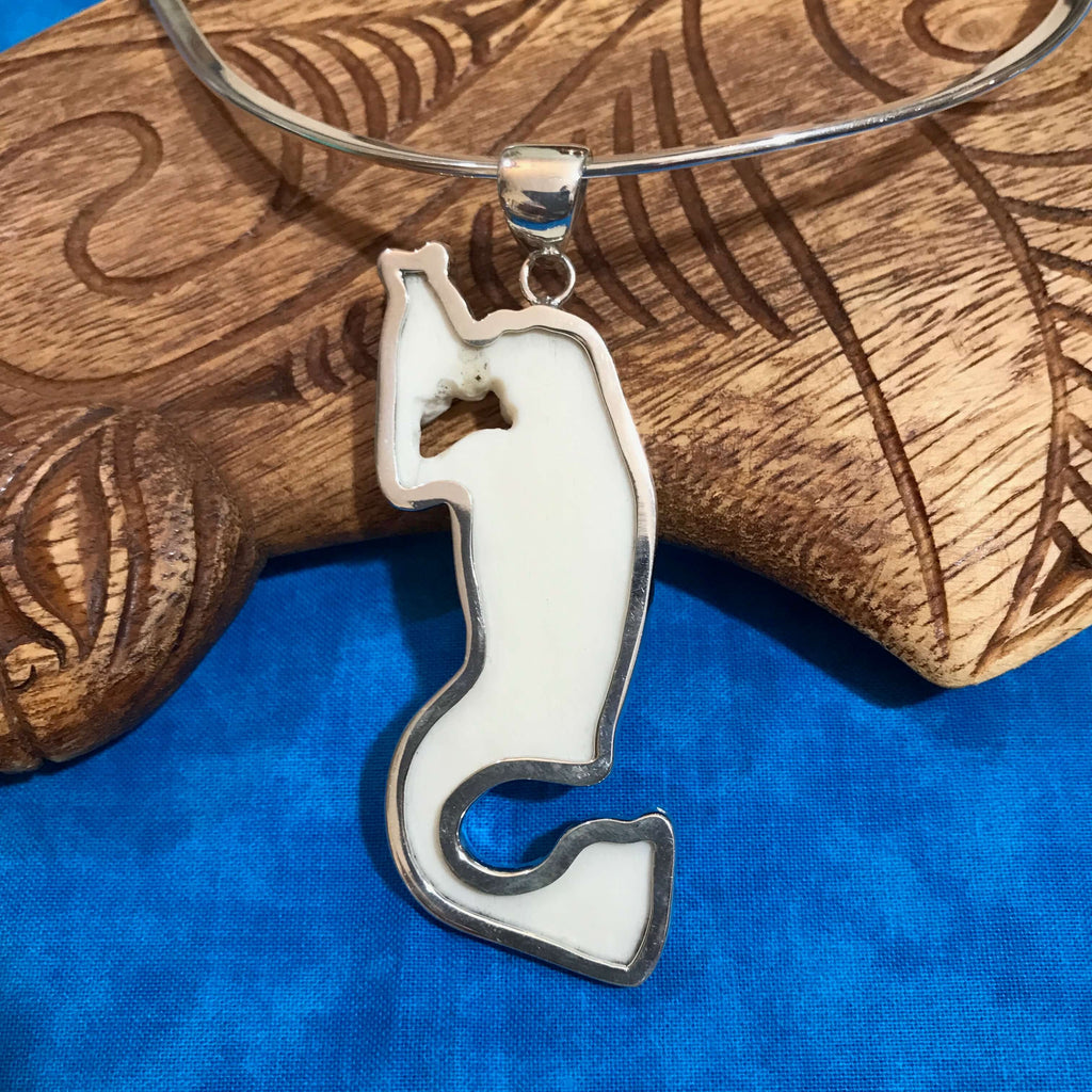 Back view showing the smooth bone surface of a mermaid pendant set in stirling silver