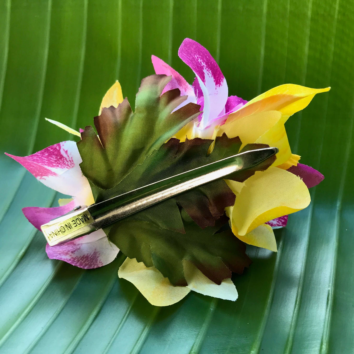 Back view of a purple and yellow flower hair clip