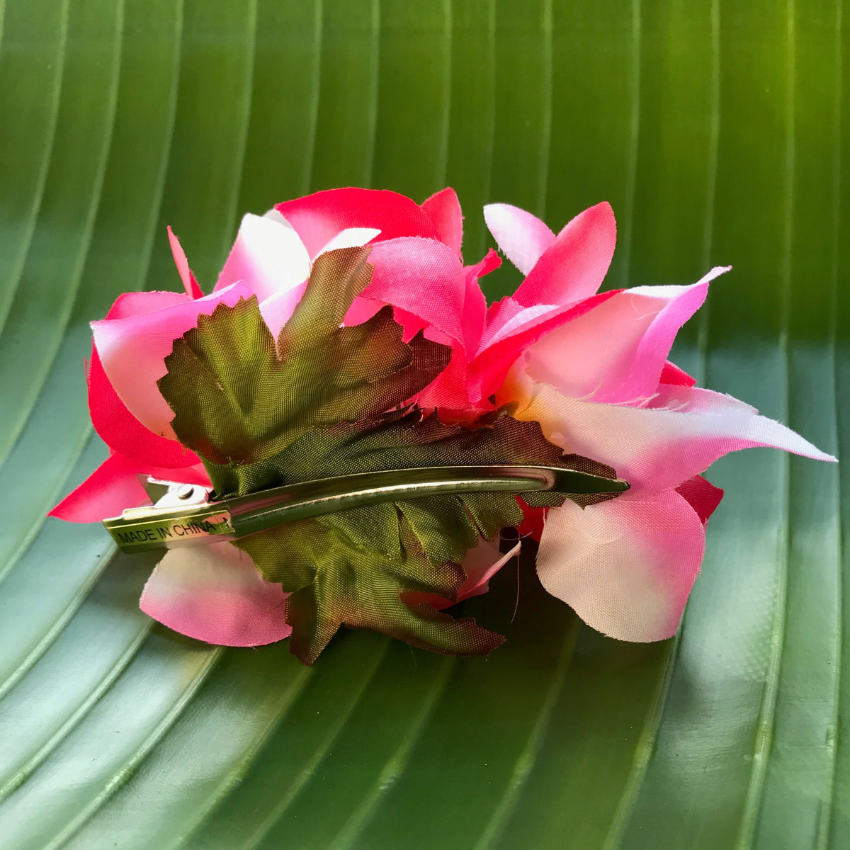 Back view of a pink and white orchid hair clip