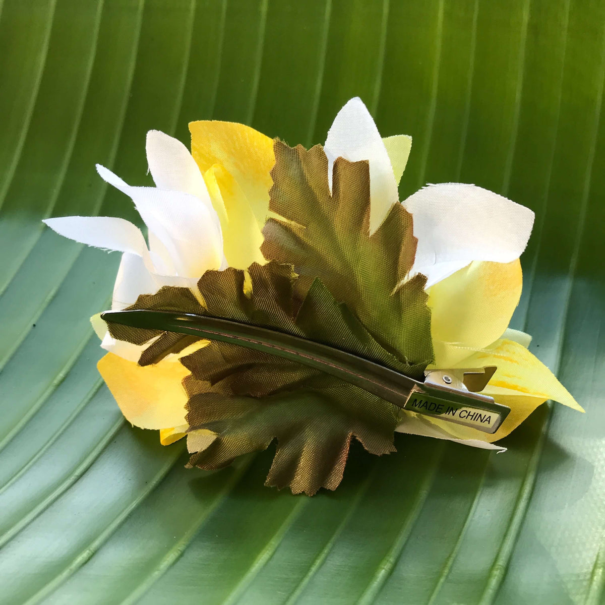 Back view of a white and yellow orchid flower hair clip 