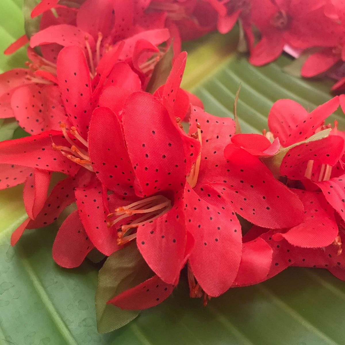 Close up view of Hawaiian silk headband with red lily flowers | Aloha Products USA