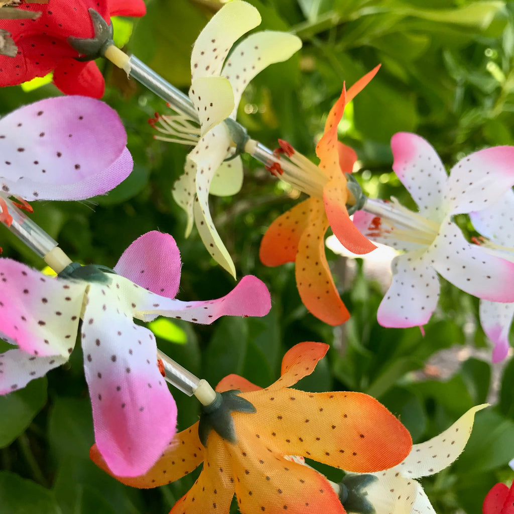 Close up view of a lily flower Hawaiian silk lei with rainbow colors | Aloha Products USA