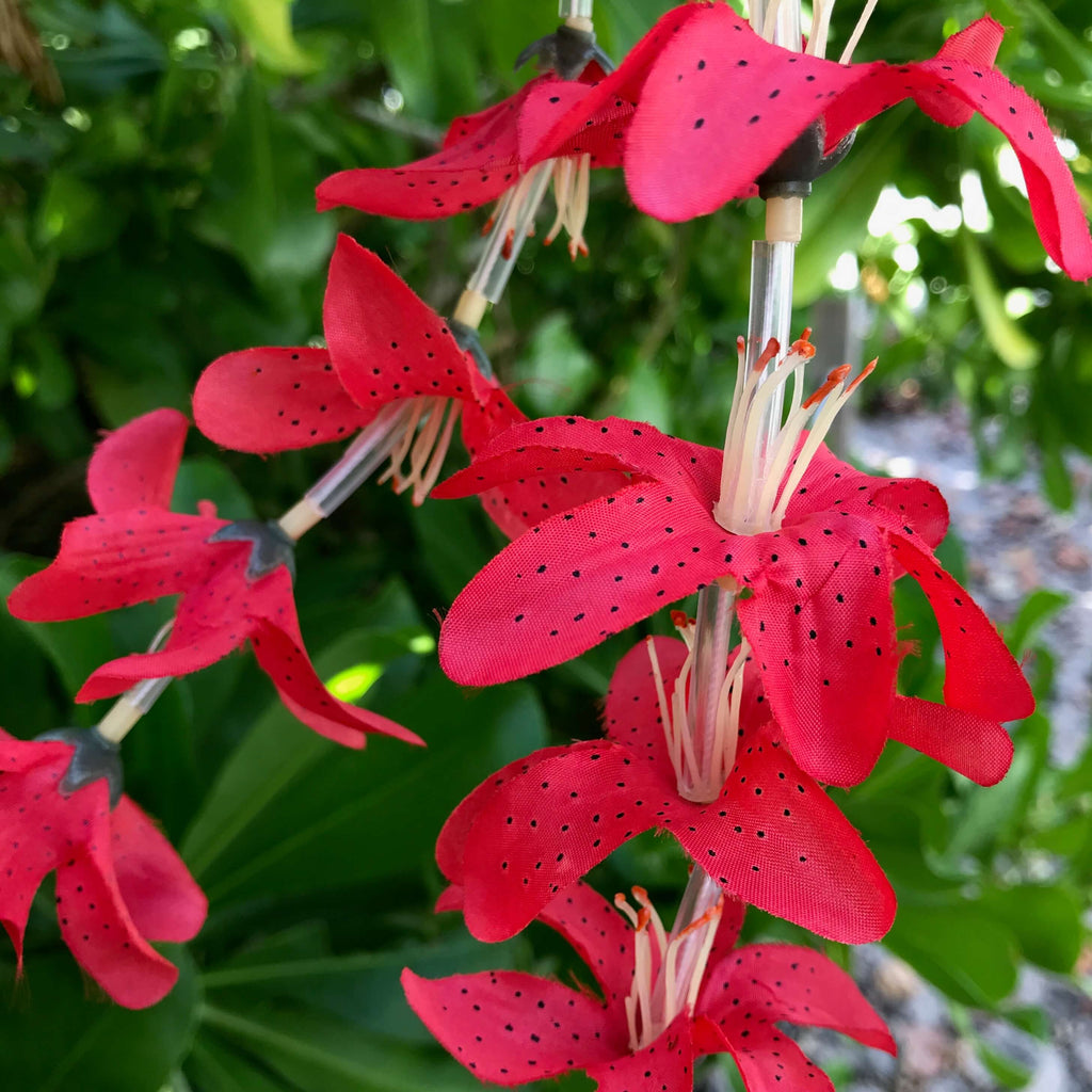 Close up view of a vibrant red lily flower Hawaiian silk lei | Aloha Products USA