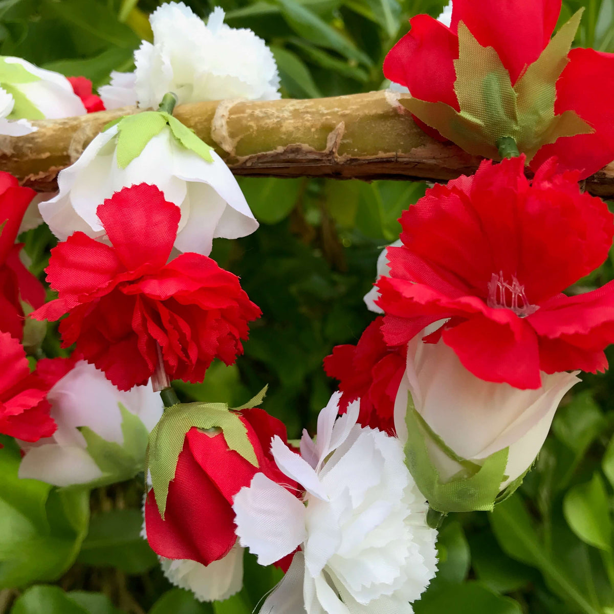 Close up view of a red and white carnation and rose flower Hawaiian lei | Aloha Products USA