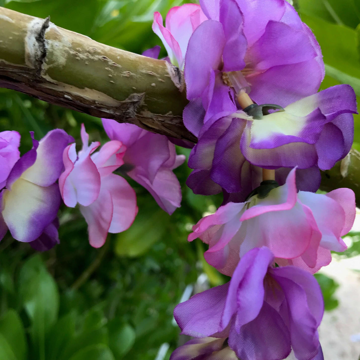 Close up view of a Hawaiian silk lei with purple and pink roses | Aloha Products USA