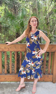 Lady wearing a beautiful Hawaiian sleeveless ruffle bottom dress in navy blue orchid | Aloha Products USA