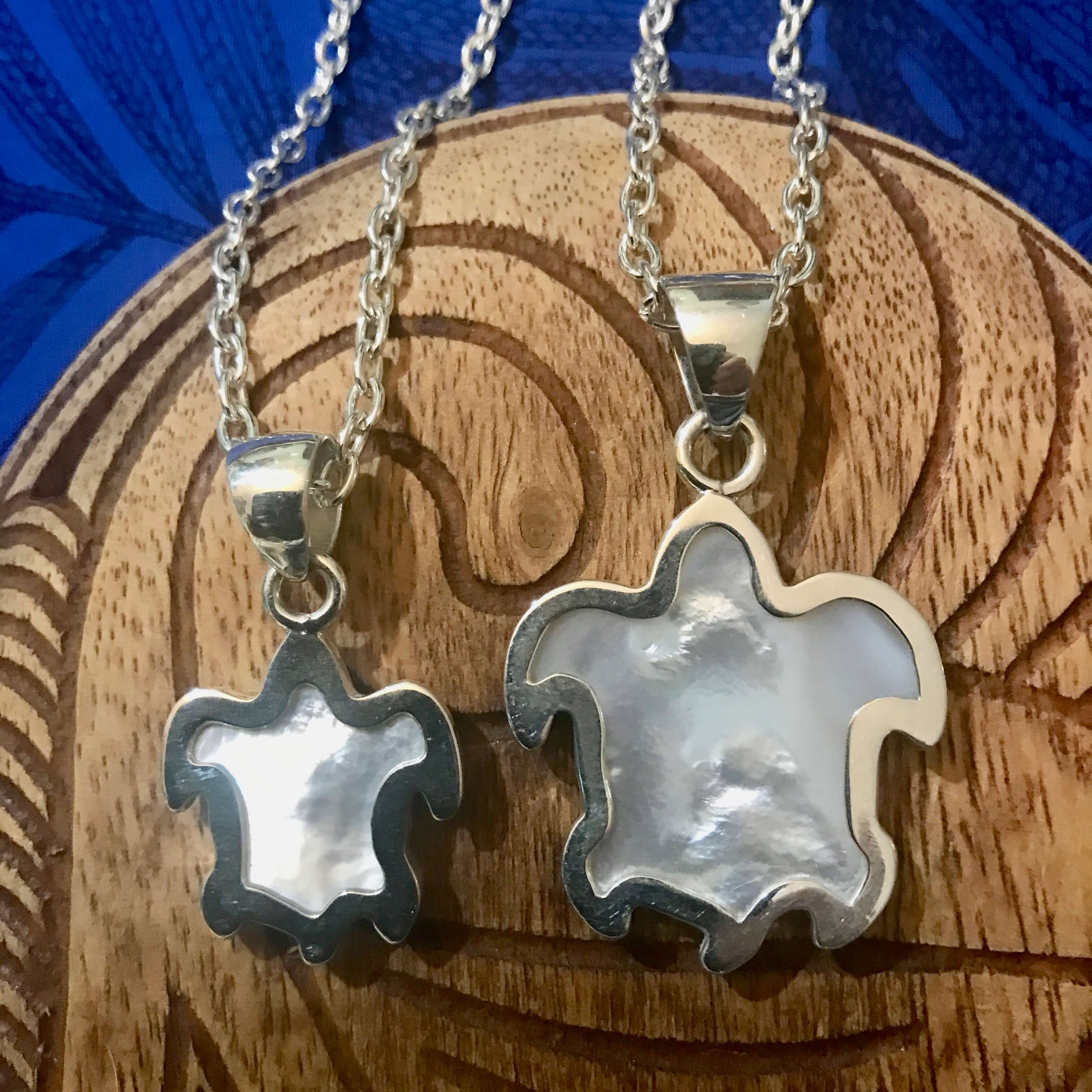 Back view of a small and large MOP turtle pendant necklaces with stirling silver settings