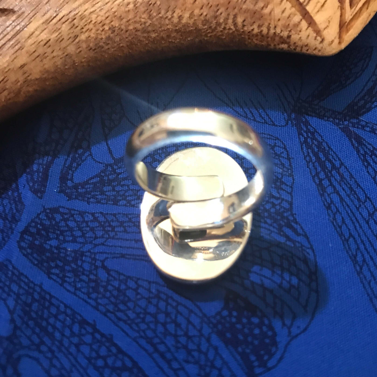 Back view of natural abalone ring showing adjustable stirling silver setting