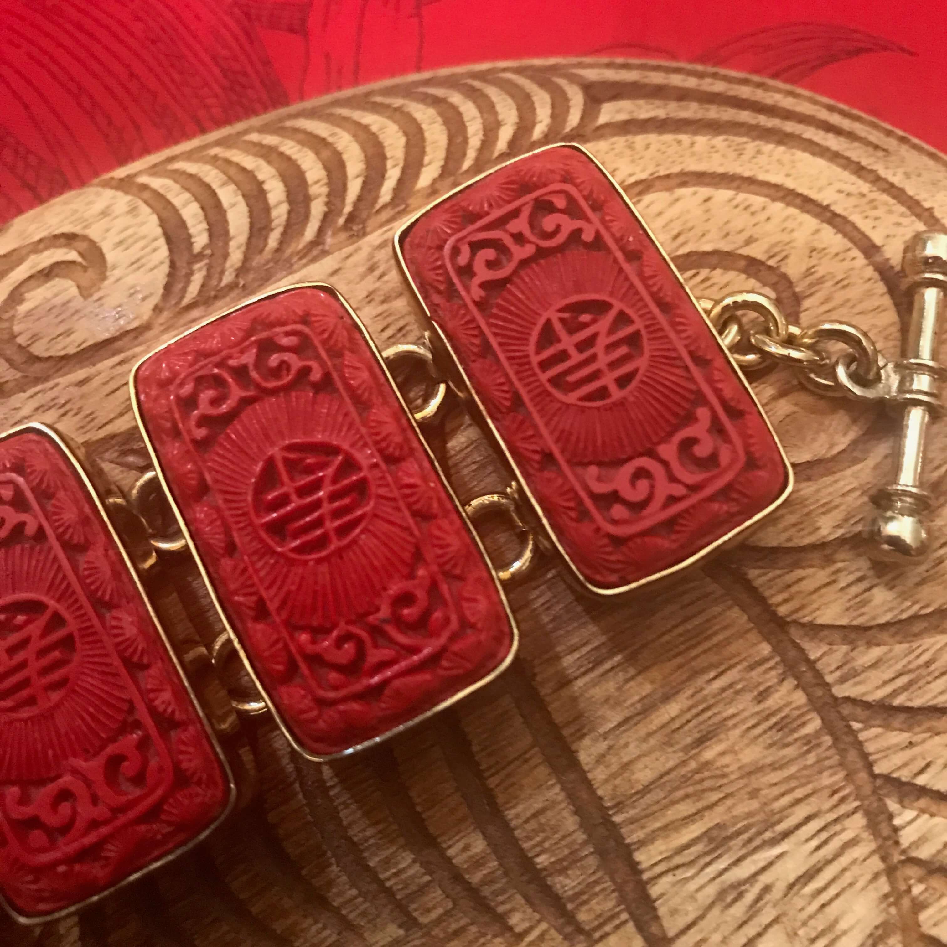 Close up view of rectangular cinnibar jewelry piece with Chinese characters | Aloha Products USA