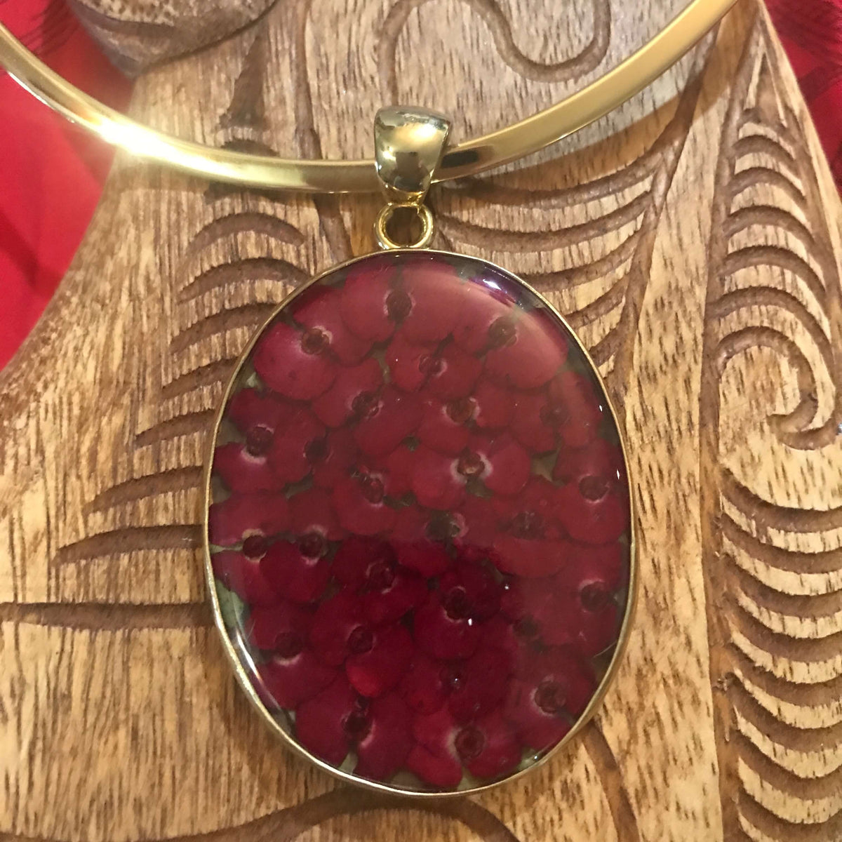 Island jewelry pendant with mini dried red flowers on a gold tone neck wire necklace | Aloha Products USA