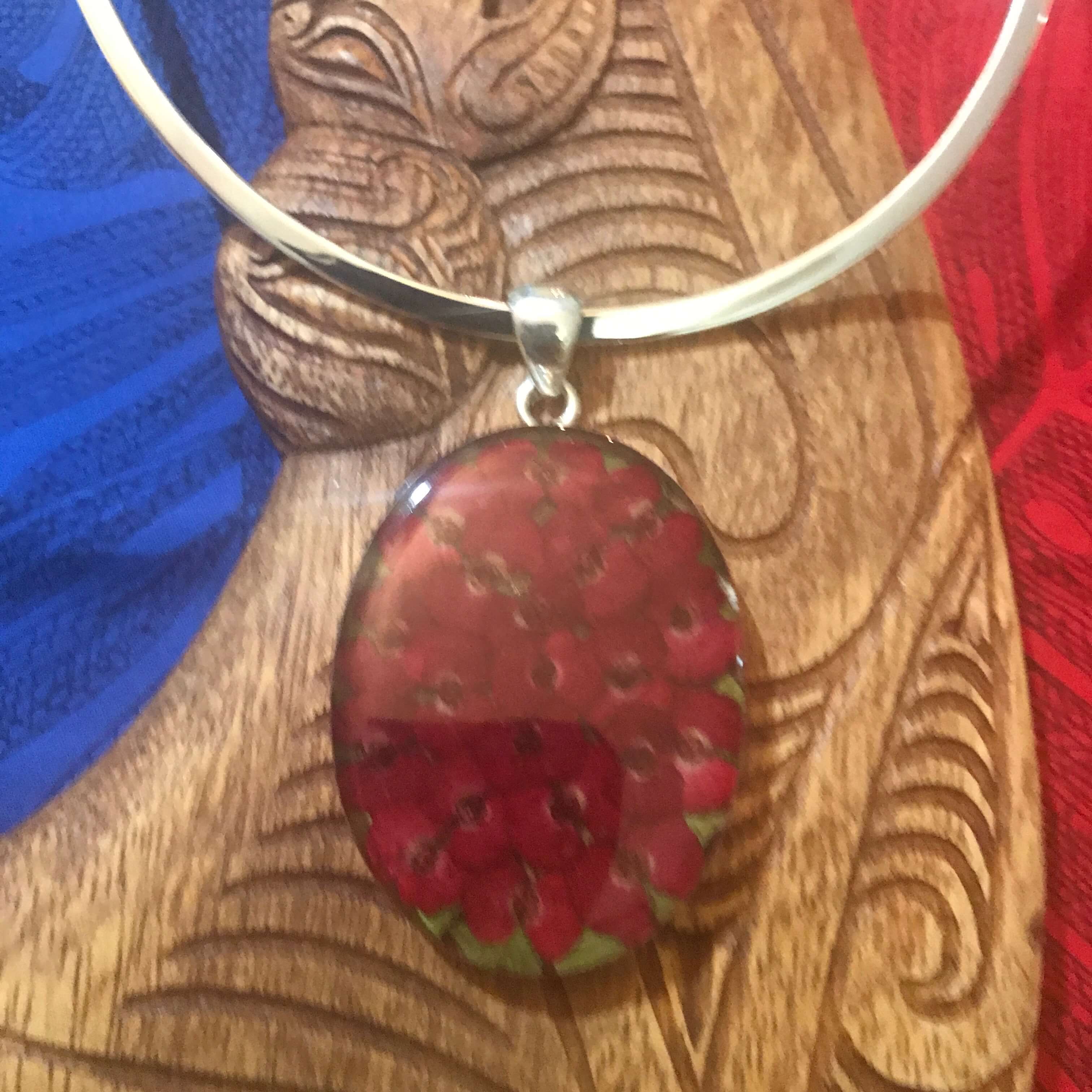 Close up view of a stirling silver pendant necklace with mini dried red flowers Aloha Products USA