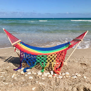 Rainbow colored hammock for 18 inch dolls set up at the beach